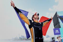 Newly-crowned Formula E champion Jean-Eric Vergne holding the French flag aloft against the backdrop of the New York skyline