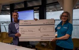 Dave Cockwell presents a cheque to a representative from the Children's Sailing Trust - Image Credit Richard Langdon